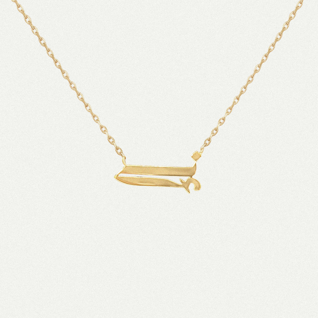 18 karat yellow gold Arabic letter necklace on a gold chain.