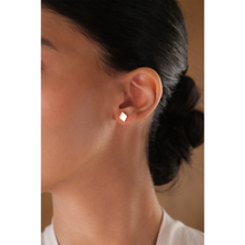 Load image into Gallery viewer, Sadu design 18k yellow gold stud earrings on a girl.
