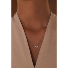 Load image into Gallery viewer, 18k white gold arabic letter necklace on a girl.
