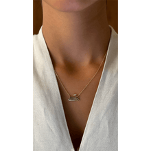 Load image into Gallery viewer, 18-karat yellow gold Triple Arabic letter necklace with yellow gold chain and with two natural diamonds on a girl.
